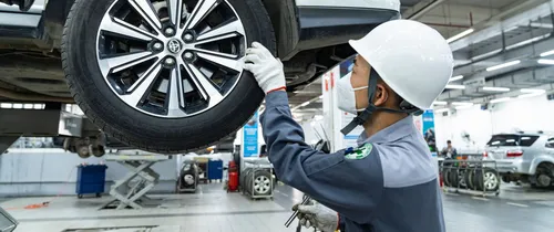 Kỹ thuật viên Toyota kiểm tra bánh xe trong khu vực dịch vụ
