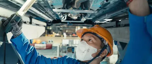 Kỹ thuật viên kiểm tra phía dưới xe Toyota trên cầu nâng